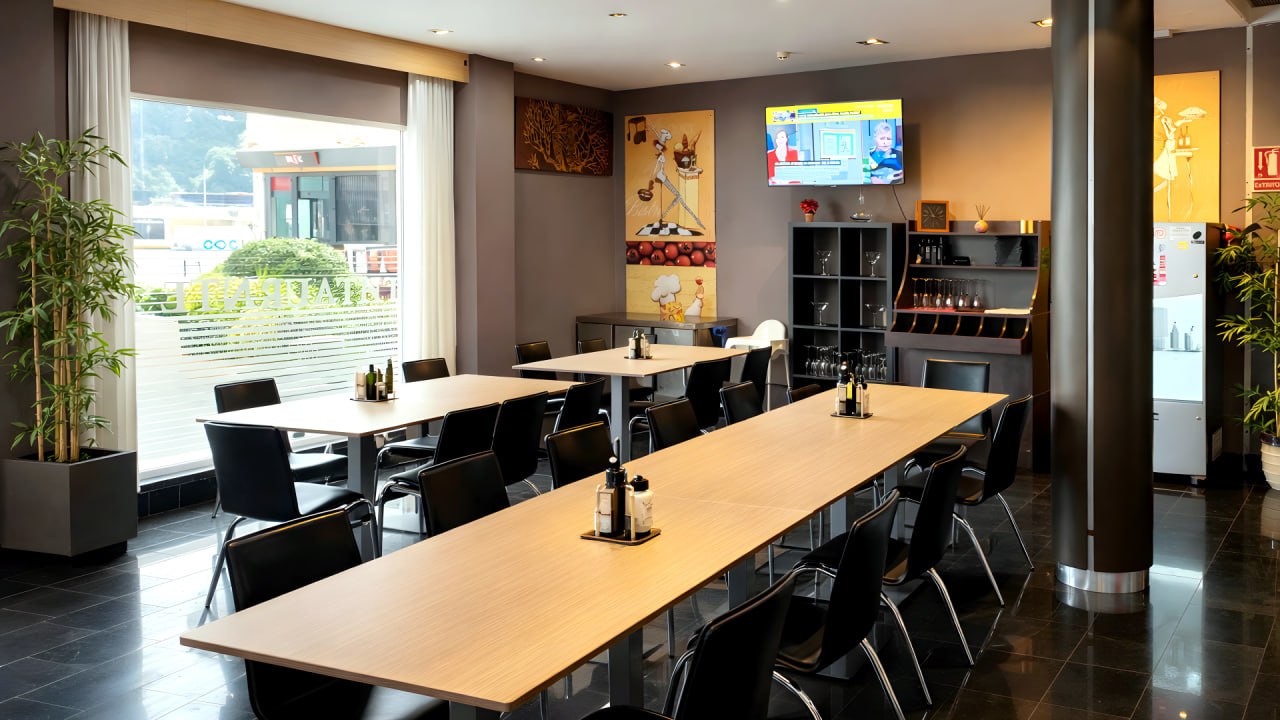 Comedor de la cafetería con mesa larga para grupos en Sagunto