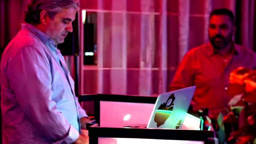 DJ booth con iluminación profesional en evento nocturno