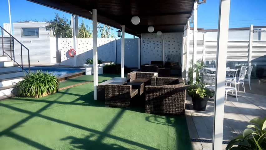 Zona lounge con sofás de ratán junto a la piscina para eventos