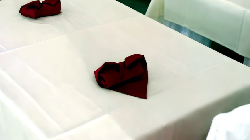 Detalle romántico de servilleta doblada en forma de corazón para boda