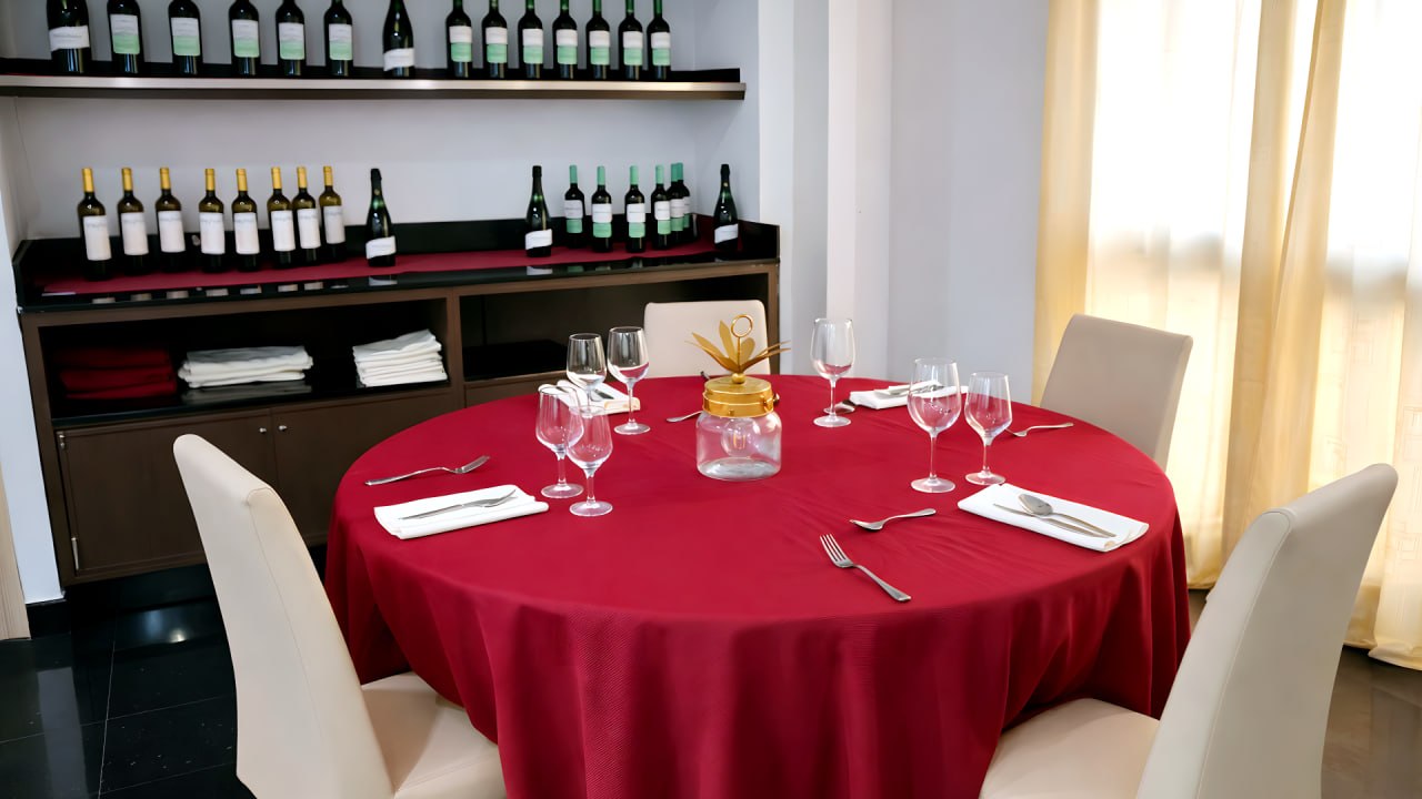 Mesa redonda con bodega de vinos al fondo en el comedor