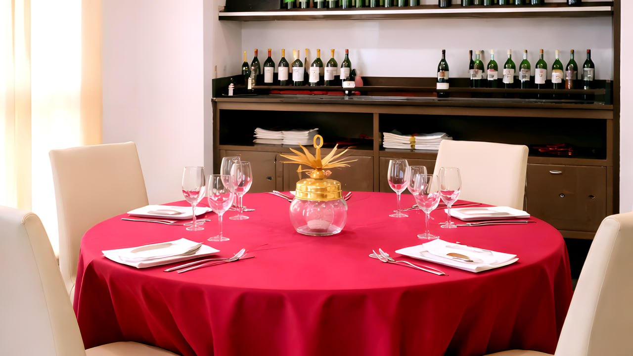 Mesa redonda elegante con mantel rojo en el comedor del Hotel Ruta Romana