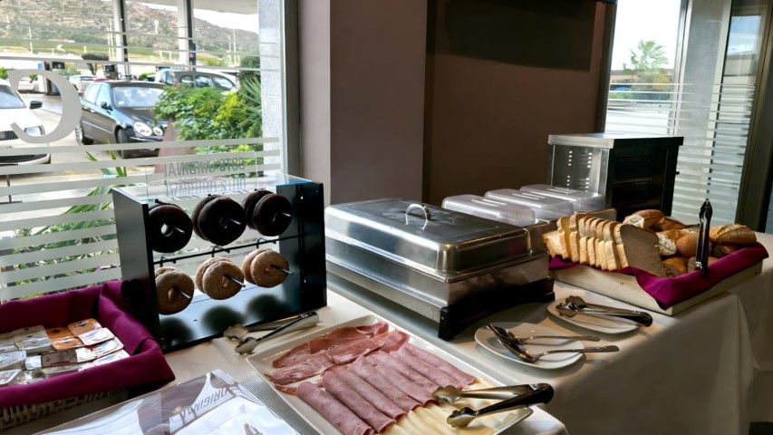 Zona de donuts y fiambres con vistas al exterior del hotel