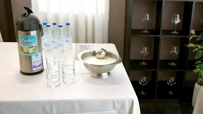 Estación de bebidas con termo de leche, agua y vasos