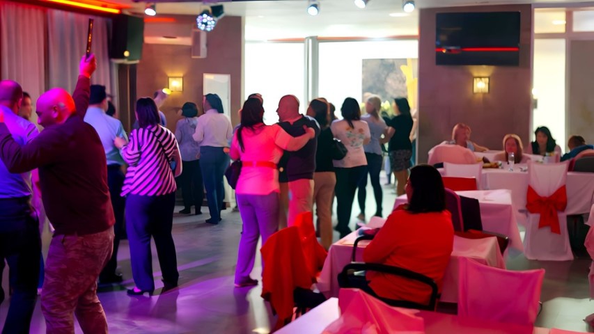 Invitado levantando el brazo bailando con energía en fiesta