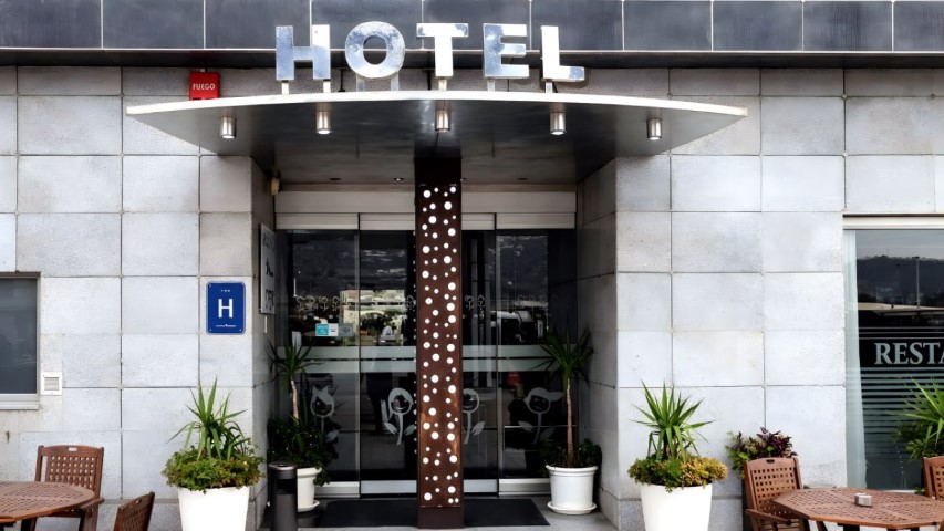 Entrada principal del Hotel Ruta Romana con cartel HOTEL y columna decorativa