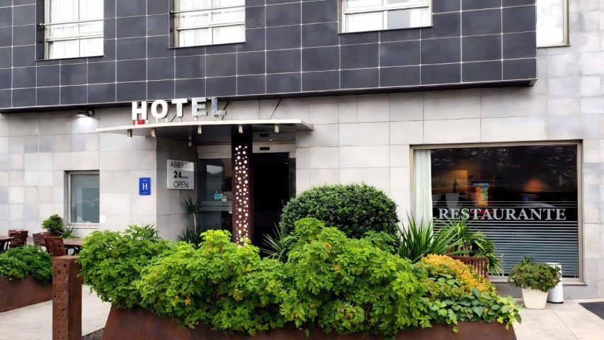 Fachada completa del hotel con jardinería cuidada en Sagunto