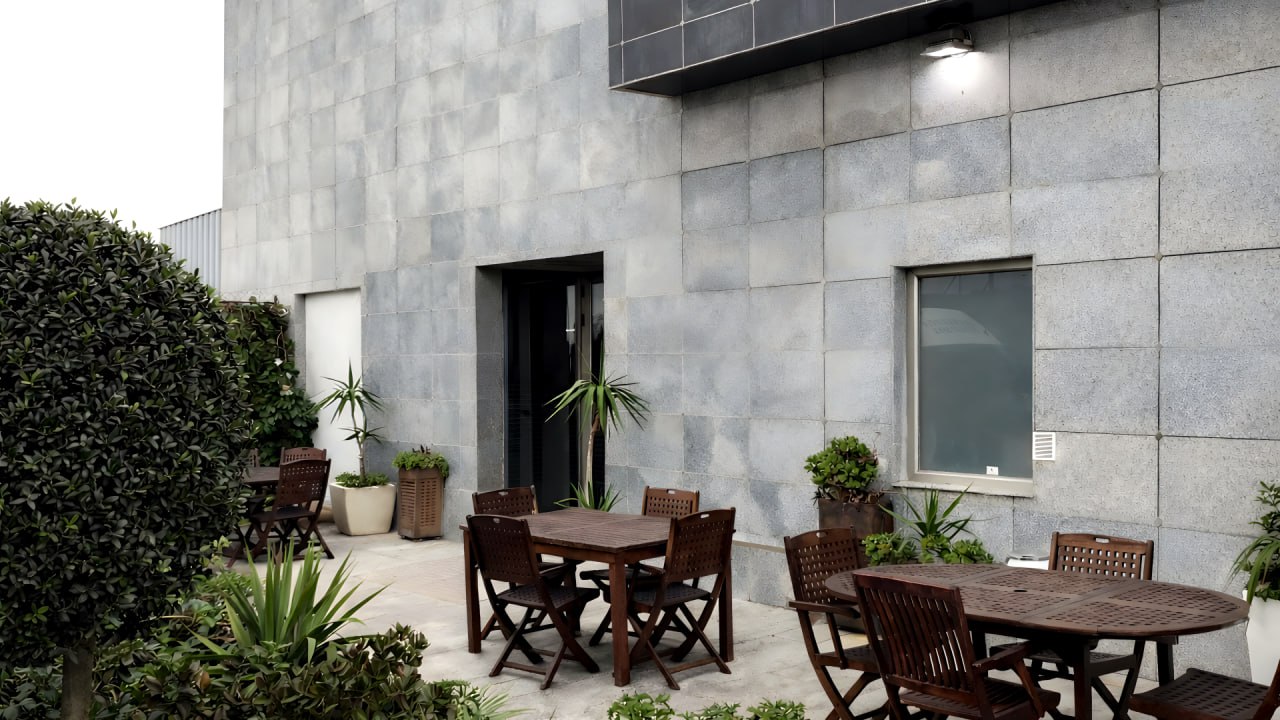 Terraza lateral con fachada de piedra del hotel