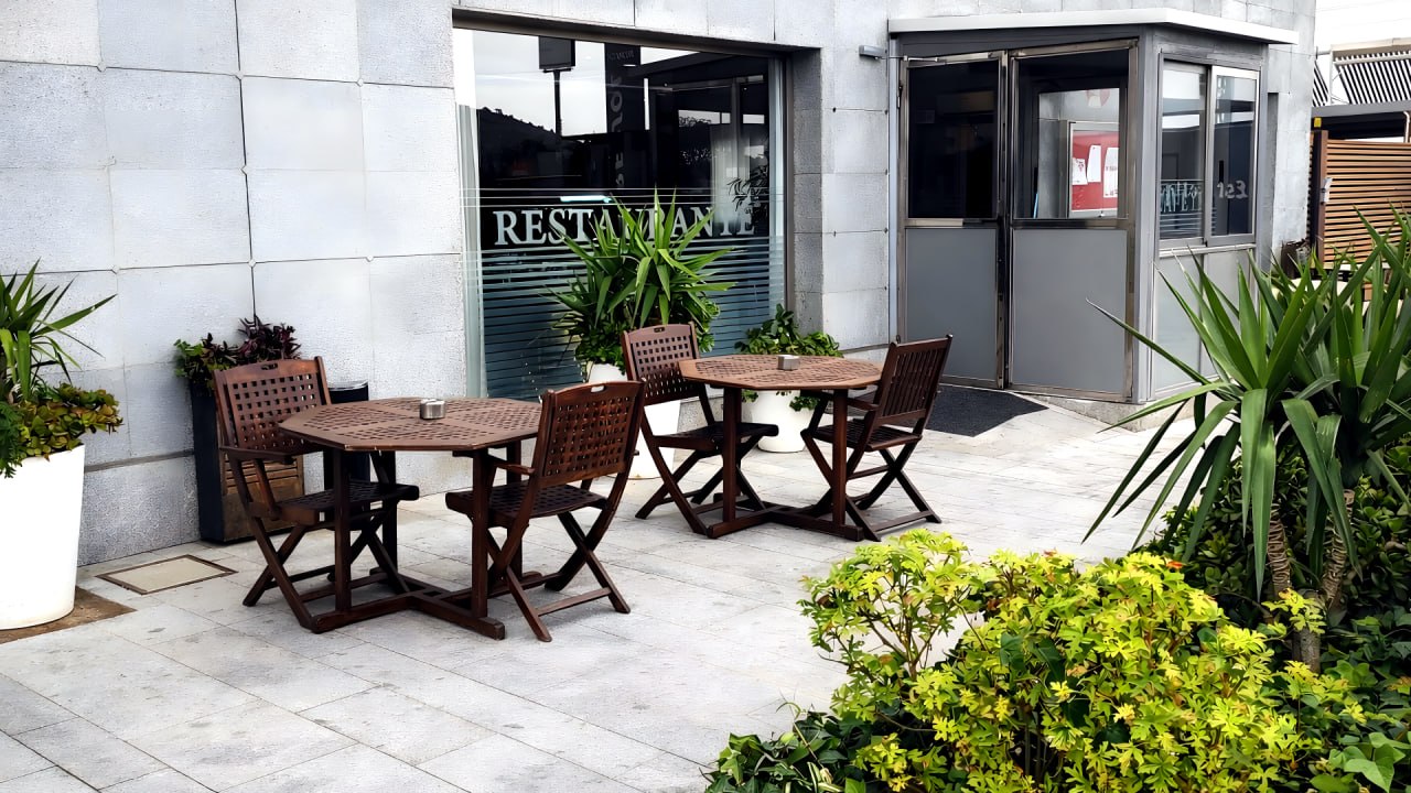 Terraza exterior con mesas de madera del hotel