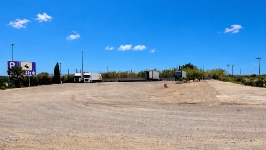 Tres camiones TIR aparcados con cartel de vigilancia 24 horas visible