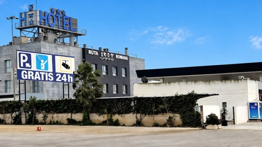 Primer plano del cartel de parking con icono de camión y gratis 24h