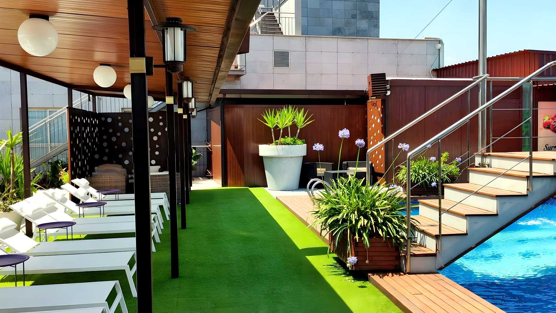 Escaleras, deck de madera y césped en la piscina del Hotel Ruta Romana